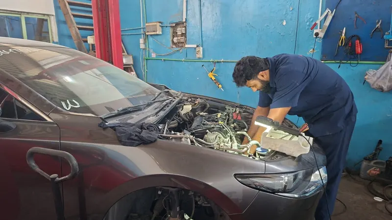 Technician inspecting an engine bay with a work light